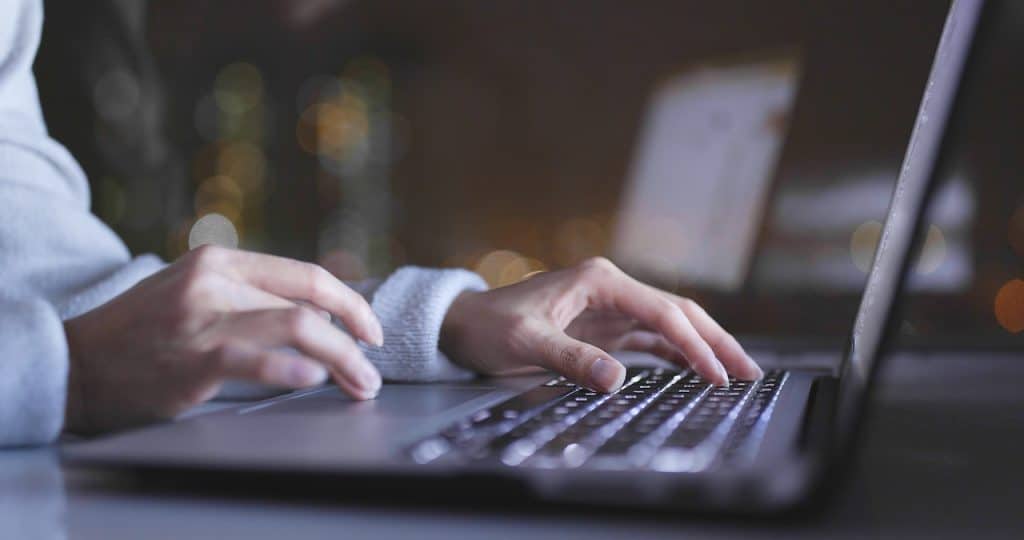 woman on laptop practicing email security as she composes email