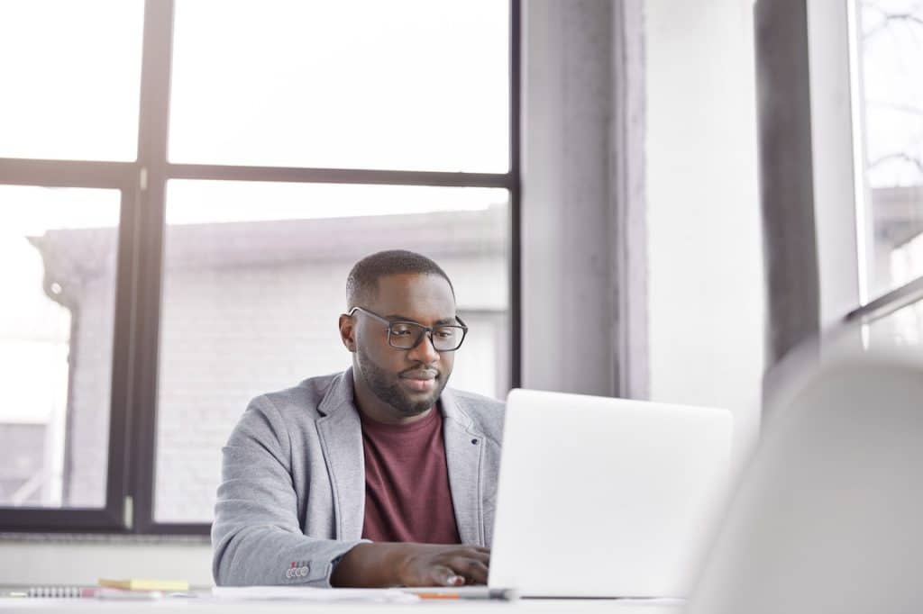 male office worker receiving remote computer support on his laptop