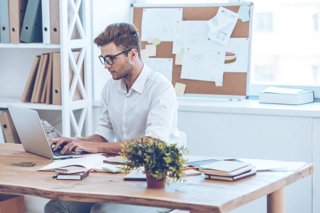 man working at desk using office 365 solutions
