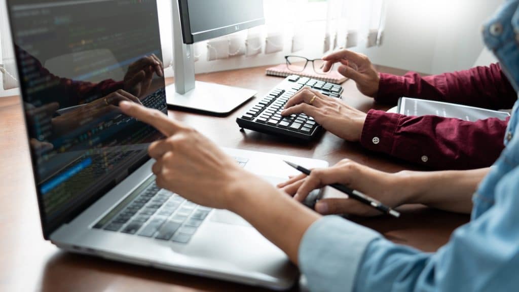 team of employees working at desk on it solutions