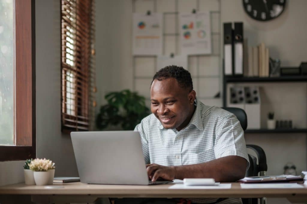 man working from home on laptop at desk