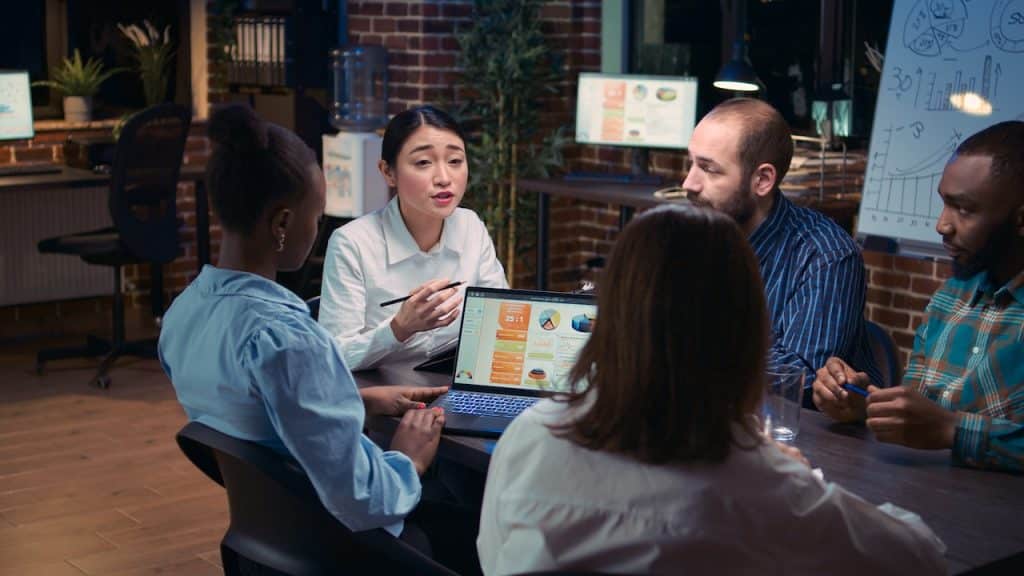 colleagues in meeting using outsourced it support services for their presentation