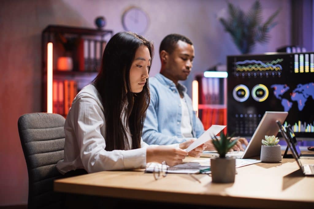 coworkers sitting at desk working on data recovery for company