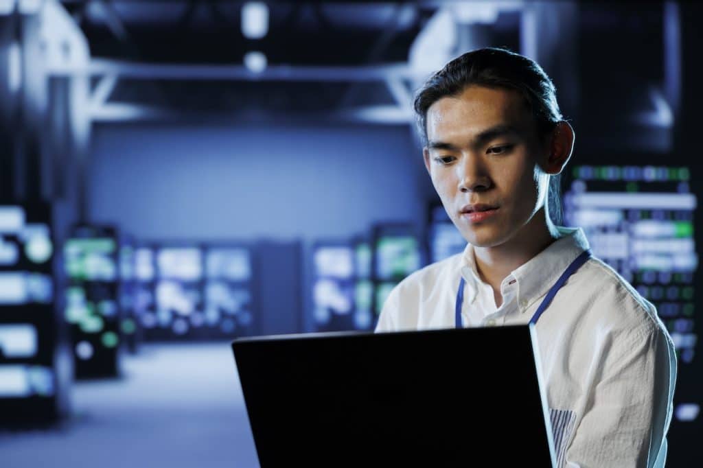 IT professional in server room working on network optimization