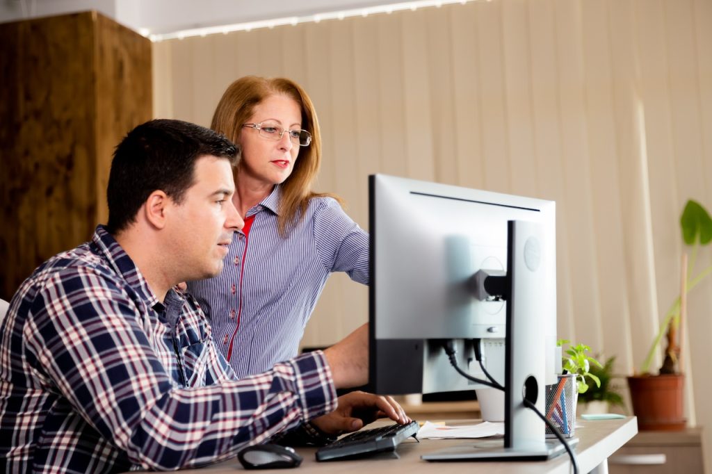 coworkers in office working on computer with help from professional it services