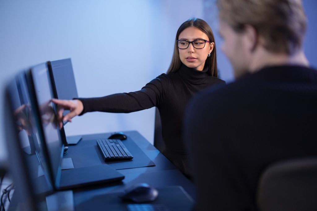 it support and services professionals discussing issues at computer in office